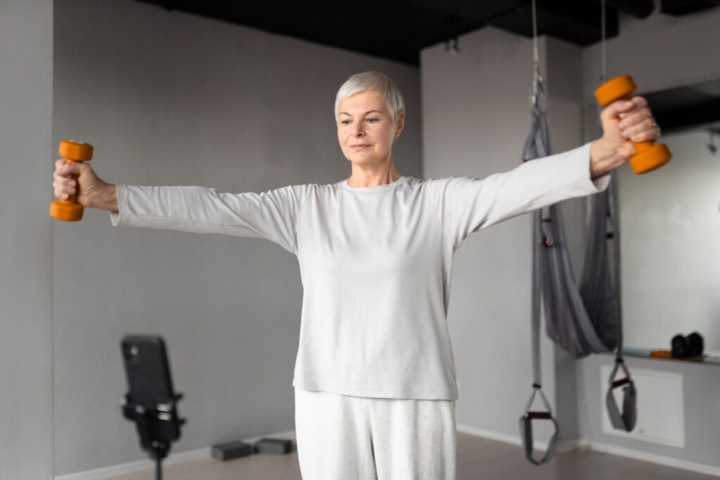 senior woman filming herself doing fitness exercises gym 23 2149230422