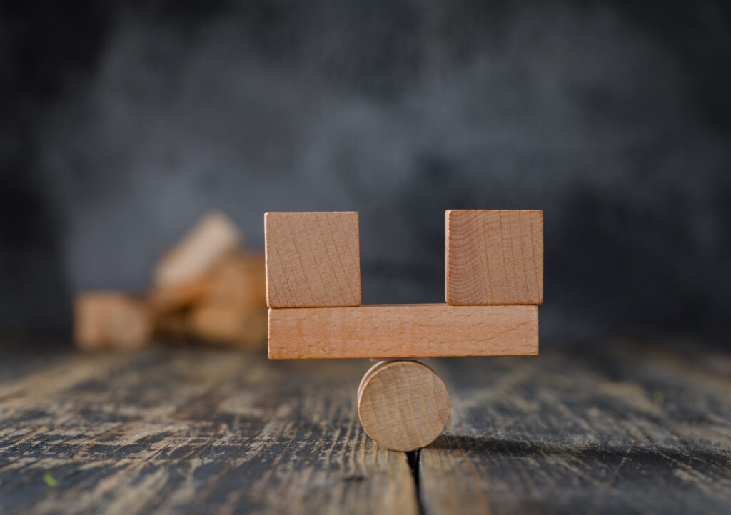 business and financial accounting concept with wooden blocks on wooden and foggy background side view.